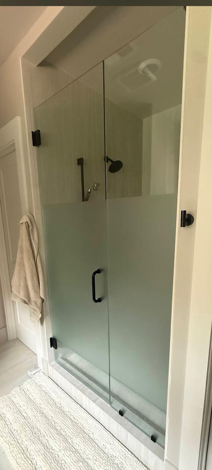 Frameless glass shower door with white tile