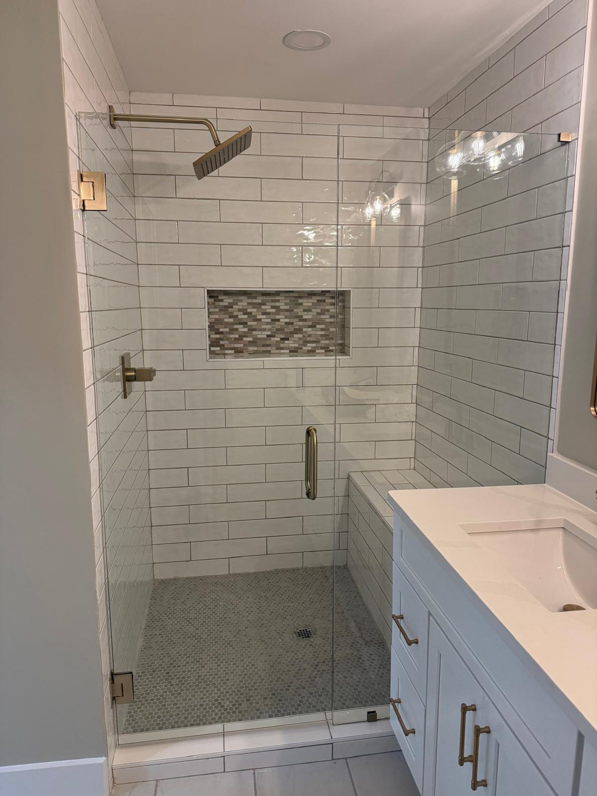 Frameless glass shower door with white subway tile