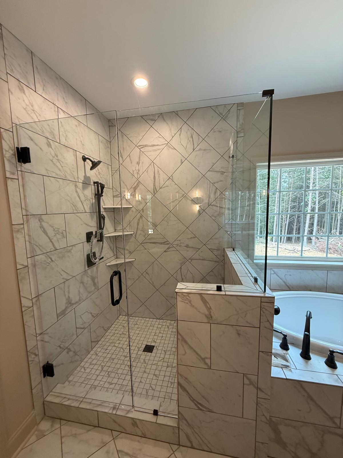 Walk-in shower with a fixed glass panel and marble-look tile